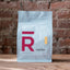 Rōst Coffee 12oz bag of Costa Rica La Pastora whole bean coffee standing on a wood surface against a brick wall