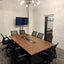 Meeting room at RŌST Coffee in Chillicothe with 10-person walnut conference table and presentation TV