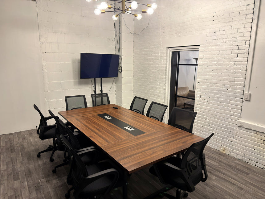 Meeting room at RŌST Coffee in Chillicothe with 10-person walnut conference table and presentation TV