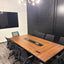 Conference table and wall-mounted glass markerboard with black accent wall